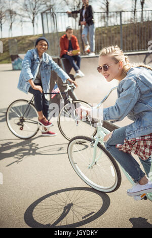 teenagers having fun and riding bicycles in skateboard park, bike riding city concept Stock Photo