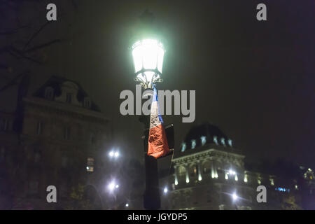 A French blue white and red flag hanging on a street lamp at republique.homage at the victims of the terrorist attacks in Paris the 13th of november. Stock Photo