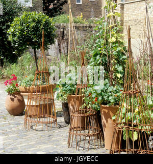 Pot plants and sculptures in garden Stock Photo