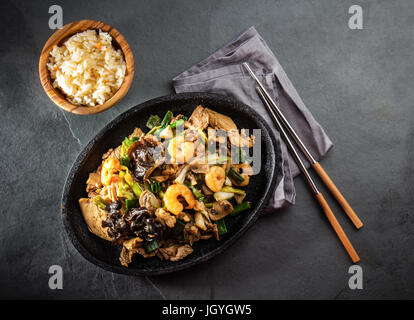 Chinese food. Te pam sao. Pan of fried beef, pork, chicken, shrimps, shiitake mushroom, champions and spring onion. Parillada china served with rice o Stock Photo