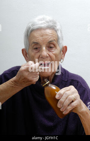 senior woman taking syrup Stock Photo