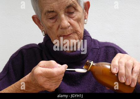 older woman taking syrup Stock Photo