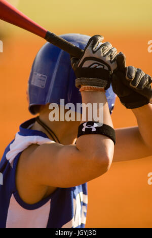 A female baseball player at bat Stock Photo