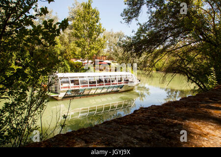 Pleasure boat on the river Tagus / Tajo as it passes the grounds of the royal palace at Aranjuez in the Madrid province of Spain Stock Photo