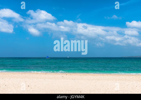 BORACAY, WESTERN VISAYAS, PHILIPPINES - JANUARY 14, 2015: Wide angle view of sunny day in Puka Beach. Two boats are sailing in a mixed green and blue  Stock Photo