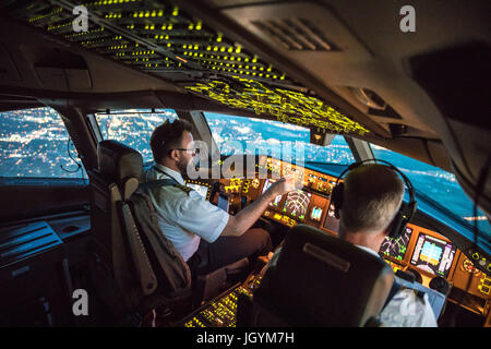 Two Pilots Departing out of Dallas Fort Worth Airport. Crew resource management taking place, both working together. In the background parts of Dallas Stock Photo