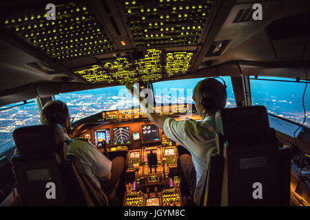 Two Pilots Departing out of Dallas Fort Worth Airport. Crew resource management taking place, both working together. In the background parts of Dallas Stock Photo