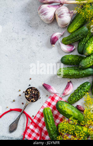 Pickled gherkins cucumber flat lay recipe background on concrete slate. Stock Photo