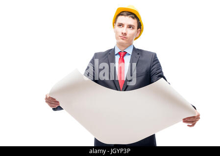 Portrait of a pensive architect with blueprints in a yellow helmet against a white background Stock Photo