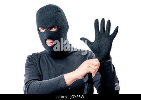 Portrait of a robber in a mask on his face straightens a glove on a white background Stock Photo