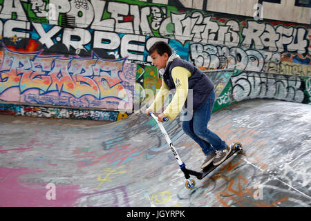 10-year-old boy riding a scooter in a skate park France. Stock Photo