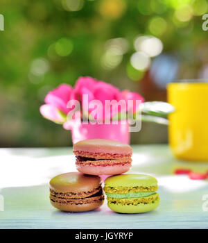 multicolored macaroons on a white wooden table, close up Stock Photo
