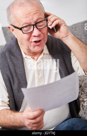 Senior citizen calling on the phone with his smartphone Stock Photo