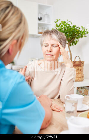 Senior citizen with Alzheimers getting nursing service at home Stock Photo