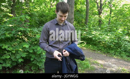 young businessman turns black spinner in the forest. Slow motion Stock Photo