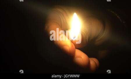 Man lights a match in darkness. Slow Motion. Stock Photo