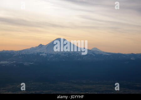 SEATTLE, WASHINGTON, USA - JAN 27th, 2017: Mount Rainier in the Cascade Range during the early morning sunlight, as seen from a started airplane from SeaTac Stock Photo