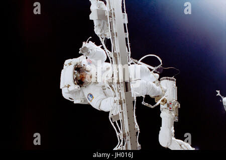 Astronaut Susan J. Helms works while holding onto a rigid umbilical and with her feet anchored to the remote manipulator system (RMS) robot arm on the Space Shuttle Discovery. This extravehicular activity (EVA), on which Helms was joined by astronaut James S. Voss (out of frame), was the first of two scheduled STS-102 space walks. The pair, destined to become members of the Expedition Two crew aboard the station later in the mission, rode aboard Discovery into orbit and at the time of this EVA were still regarded as STS-102 mission specialists. Stock Photo