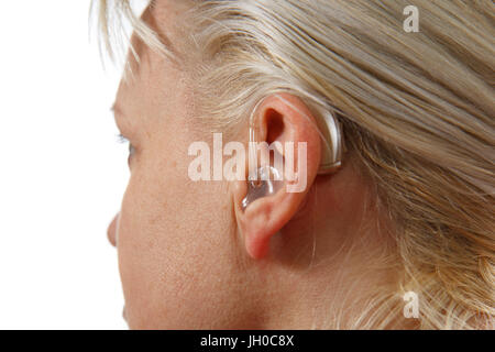 modern digital hearing aid in woman's ear Stock Photo