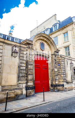 A beautiful bright red door on an old building in Paris, France Stock Photo