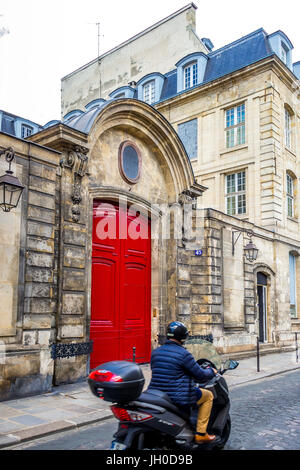 A beautiful bright red door on an old building in Paris, France Stock Photo