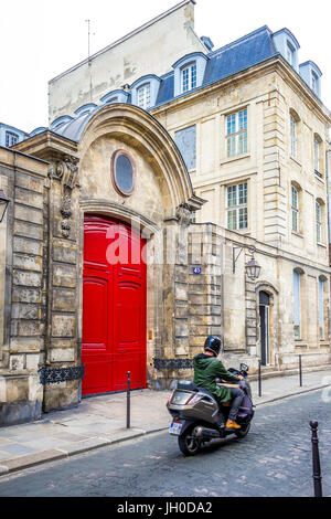 A beautiful bright red door on an old building in Paris, France Stock Photo