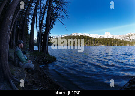 A fisherman waits for a bite on the shore of Lake Mary in Mammoth Lakes, CA. Stock Photo