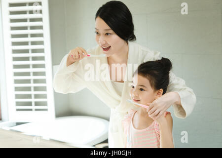Mother teaching daughter brushing teeth Stock Photo