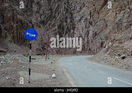 Mountain street with traffic signs on high altitude Ladakh-Leh road in Himalayan mountain, state of Jammu and Kashmir, India. Stock Photo