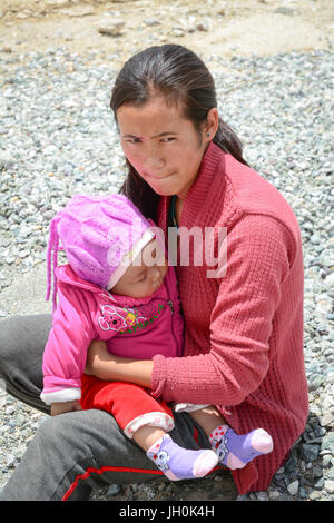Leh, India - Jul 17, 2015. A Tibetan woman with her son at a village in Nubra Valley, India. 65% of children attend school, but absenteeism of both st Stock Photo