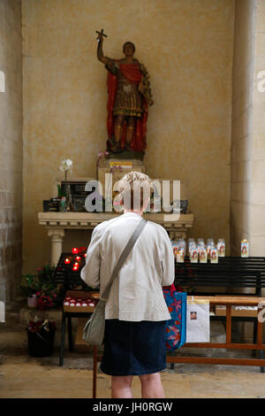 Abbaye-aux-Dames, Caen. Holy Trinity abbey church. Woman praying to Saint Expedit. France. Stock Photo