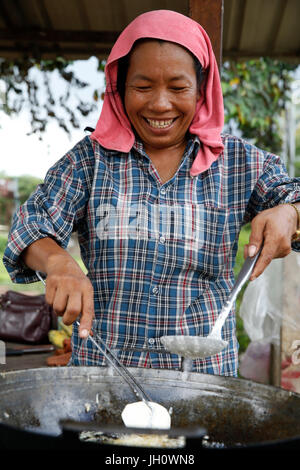 Cambodian muslim Ry Chanty makes and sells banana fritters, peanuts and fruit, and also raises chickens. She borrowed 1,4 million riel from Chamroeun Stock Photo
