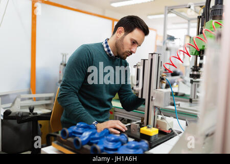 Two young handsome engineers working on electronics components Stock Photo
