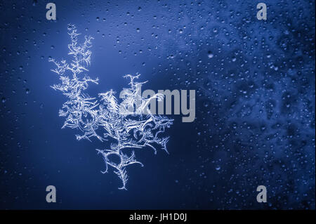 blue toned ice crystals forming on wet glass Stock Photo