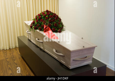 A coffin with a flower arrangement in a morgue Stock Photo