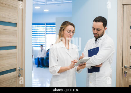 Two doctors discussing diagnosis while walking Stock Photo