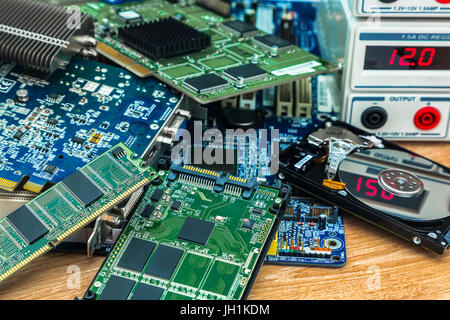 The heap of electronic boards with SSD and HDD from the computer on the service desk at the power supply Stock Photo