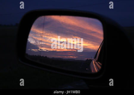 Sunset reflected in a rear view mirror. France. Stock Photo