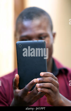 African man using a smart phone.  Lome. Togo. Stock Photo