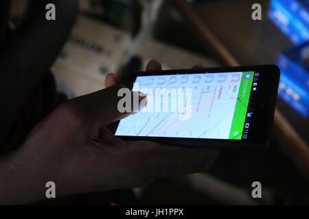 Close up of an african  man using a smart phone with a cracked screen.     Lome. Togo. Stock Photo