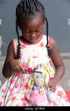 African girl playing with a doll.  Lome. Togo. Stock Photo