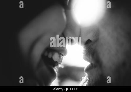 Happy couple in love touching noses and looking each others eyes. Close-up nose to nose