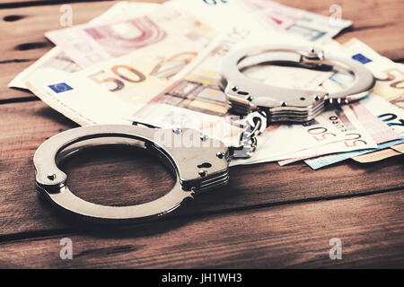 financial crime concept - money and handcuffs on the table Stock Photo