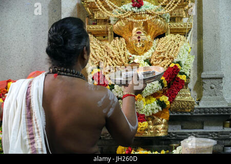 Sri Veeramakaliamman Hindu Temple.  Dakshinamurthy. Hindu Brahmin priest  performing morning puja ceremony.  Singapore. Stock Photo