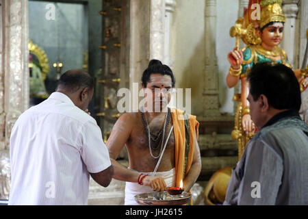 Sri Veeramakaliamman Hindu Temple.  Hindu Brahmin priest.   Hindu devotees during a morning prayer or puja.  Singapore. Stock Photo