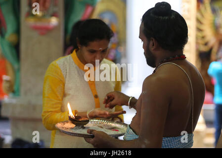 Sri Veeramakaliamman Hindu Temple.  Hindu Brahmin priest.   Hindu devotee during a morning prayer or puja.  Singapore. Stock Photo