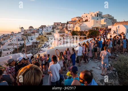 People line the town's walls, for the famous Oia sunset on the Greek island of Santorini, Cyclades, Greek Islands, Greece Stock Photo