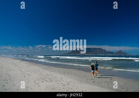 Joggers running on Blouberg Beach in the early morning, with Table Mountain in the background, Cape Town, South Africa, Africa Stock Photo