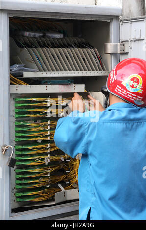 Vietnamese electrician checking plug sockets.  Vietnam. Stock Photo