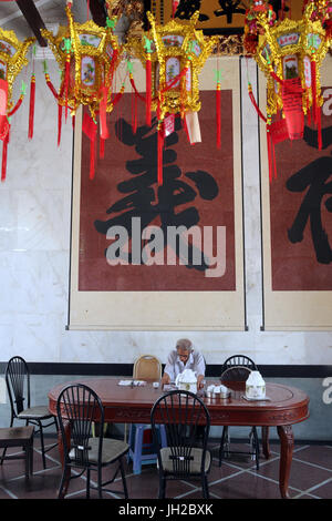 Taoist temple. Nghia An Hoi Quan pagoda. Man having tea.  Ho chi Minh City. Vietnam. Stock Photo
